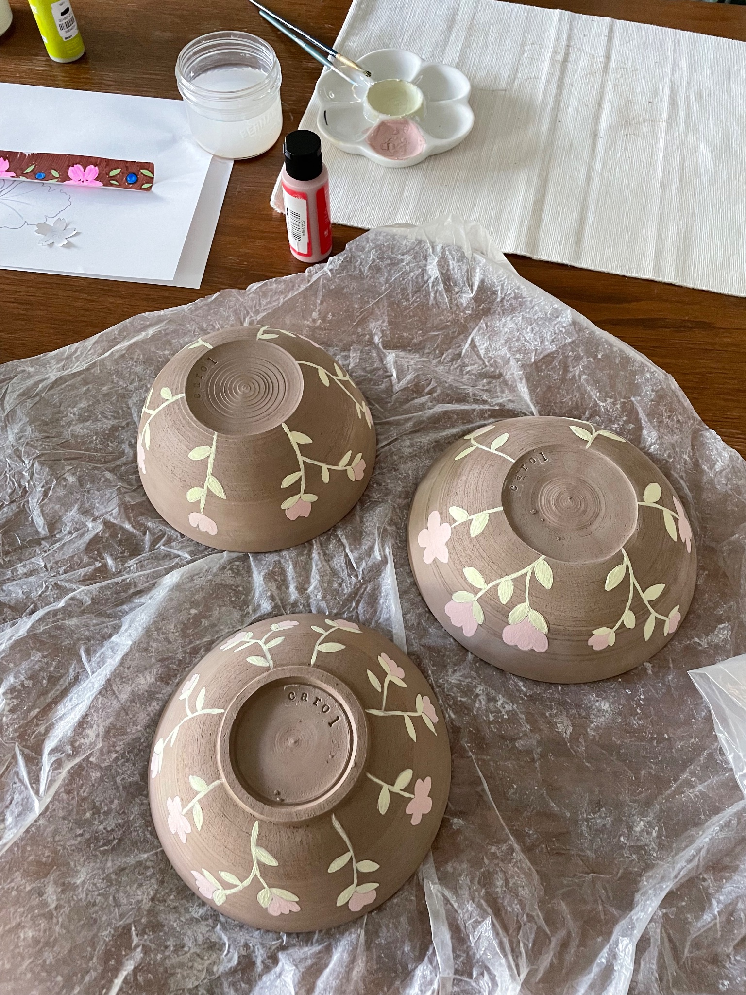 three handmade bowls thrown on the pottery wheel decorated with pink flowers all over